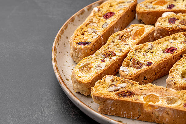 istock Italian Almond Biscotti biscuits in a rustic home made pottery bowl. Studded with almonds and cranberries, these twice-baked treats are aromatic and inviting. Ideal. 2219512508