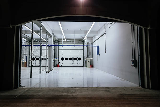 This brightly lit, spacious modern garage, with its pristine polished floor and large drive-in doors, evokes the feeling of a high-performance automotive or even an F1 team service bay