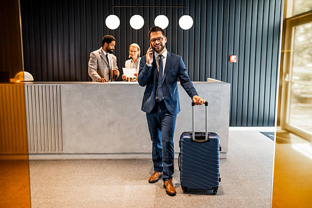 istock Businessman making a phone call while waiting at hotel reception 2219516610