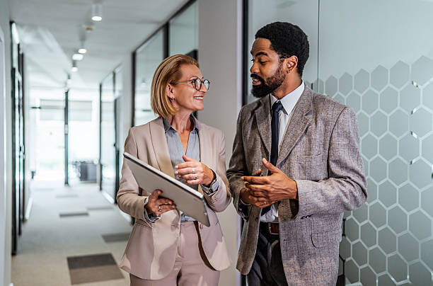 istock Businesspeople walking and talking in office corridor 2219516951