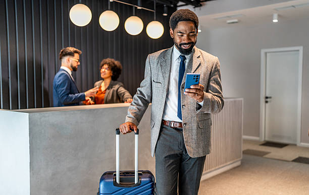 istock Business traveler checking phone at hotel reception 2219517036