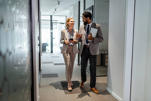 istock Businesspeople walking and talking in office corridor 2219517712