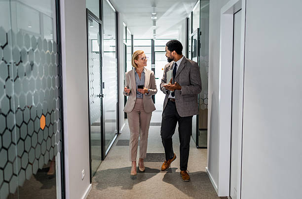 istock Businesspeople walking and talking in office corridor 2219517808