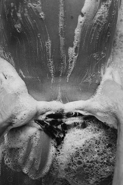 A African-American man taking a bubble bath in a tub