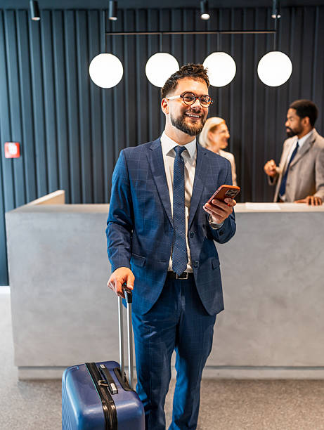 istock Businessman arriving at hotel using mobile phone 2219518181