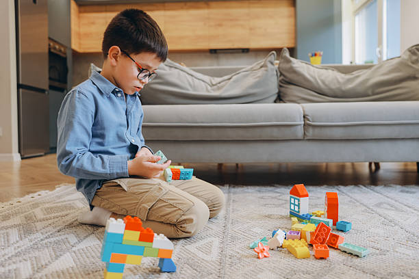 istock Boy playing with colorful building blocks at home 2219519124