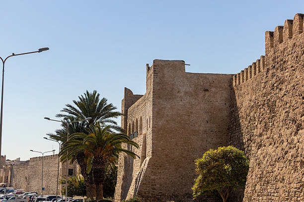 istock A weathered city wall with crenellations stands under a bright blue sky 2219519798