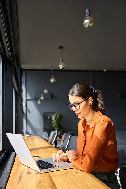 istock European mature woman using computer for finance data analysing work online. Smiling busy financial specialist latin hispanic businesswoman working on laptop pc sitting at desk in office. Vertical 2219519833