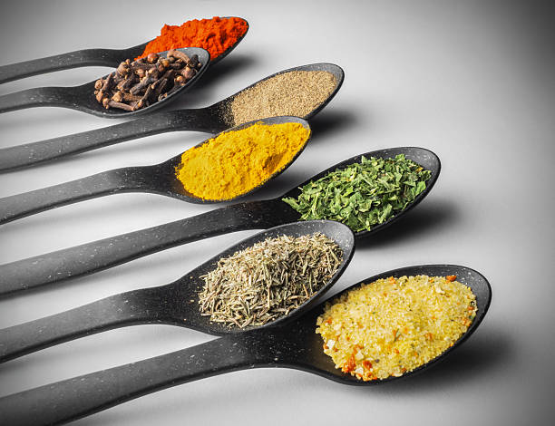 istock Assorted colorful spices on black spoons close-up 2219525124