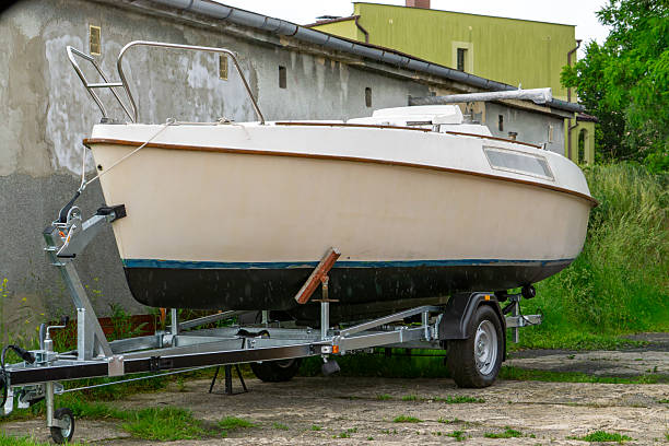 istock Old sailboat on a trailer parked next to a building 2219527373