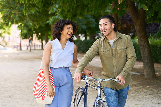 istock Happy couple walking and talking in park with bicycle 2219528943