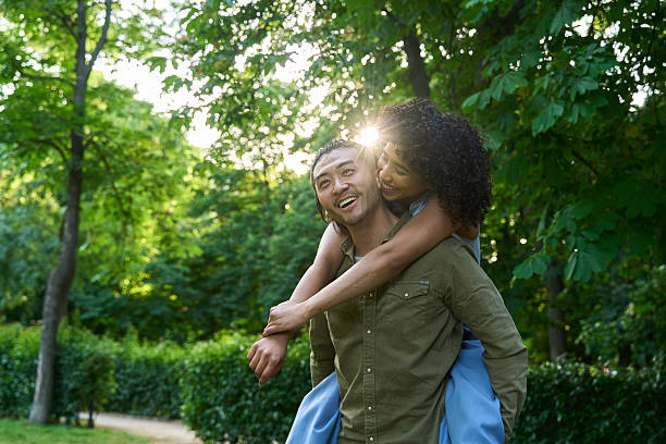 istock Happy multi ethnic couple piggybacking in green park 2219529573
