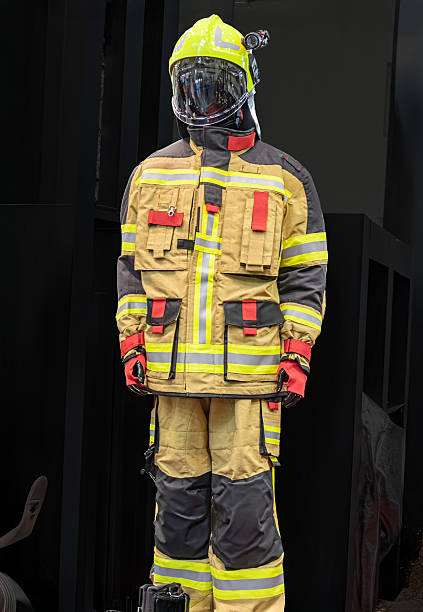 istock Firefighter in protective gear, standing before a barred window, daytime lighting Yellowred helmet, goggles, high-visibility jacket, black trousers with yellow stripes, gloves, tool or device on be 2219532029