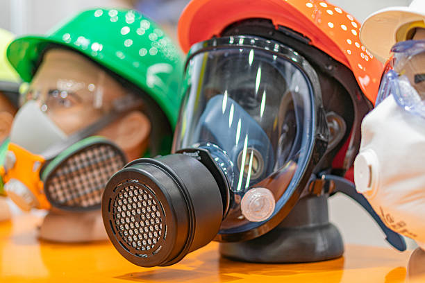 istock Collection of various respirators arranged on a flat surface with an orange hue, displayed for clear visibility Respirator types include full face and nosemouth models, some with filters attached t 2219532532
