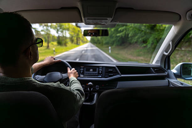 istock Driver at wheel. Forest road in spring. Front seat view. 2219533370