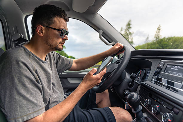 istock Driver with phone. Focused behind the wheel. Smartphone use in motion. 2219533403