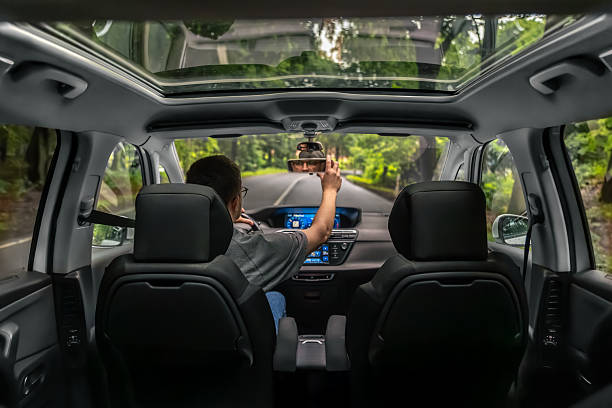 istock Forest road trip. Driver adjusts mirror. Interior car view. 2219533425