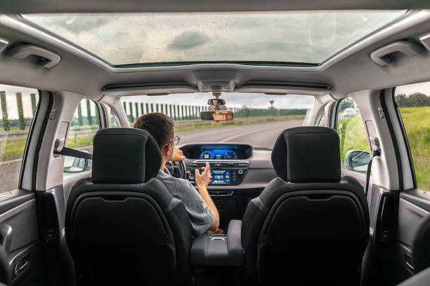 istock Car interior with panoramic roof. Driver on highway. Road trip. 2219533428