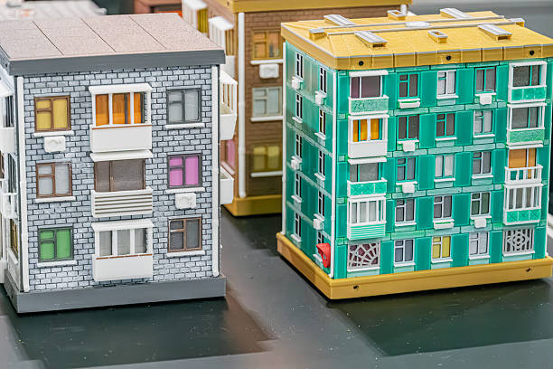 Two apartment buildings, gray and green diorama, multiple windows with shutters, open and closed, balconies, railings, ground level perspective, even lighting, realistic style