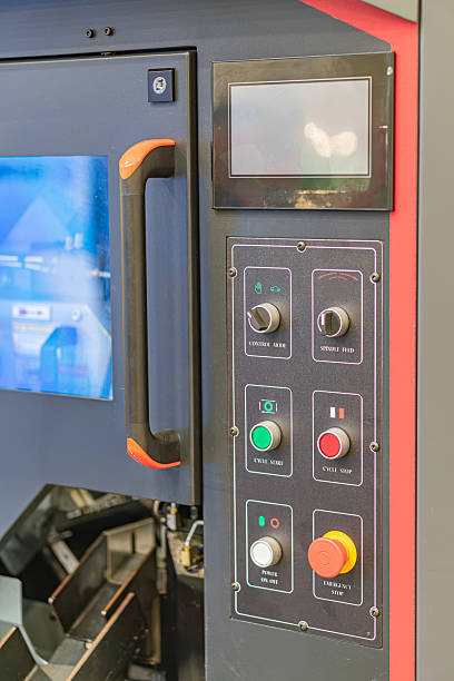 istock Close-up view of an industrial control panel with multiple red and green buttons, a blue graphical interface screen, orange accents on handles, modern design, comprehensive angle, even lighting, vivi 2219535326