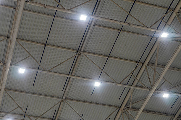 istock Indoor space with corrugated metal ceiling, skylights, natural light, soft shadows, expansive, grandeur, realistic colors, neutral tone, industrial or public building interior 2219535620