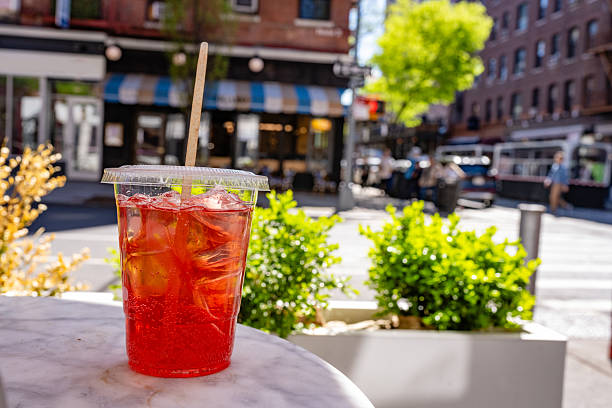 This is a color photograph of red colored ice tea on a sunny day on an outdoor cafe table in Soho NYC.