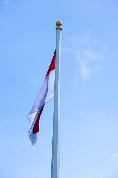 istock The red and white flag flutters in the wind with a blue sky background 2219542131