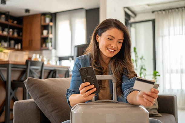 istock Woman booking a trip online using her smartphone and credit card 2219543716