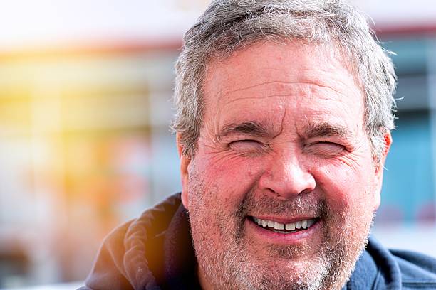 Smiling mature man posing looking at the camera posing outside