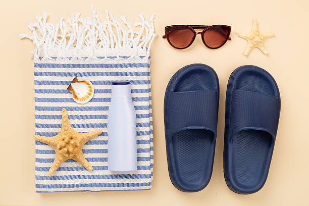 istock Beach towel with summer accessories on color background, top view 2219547786