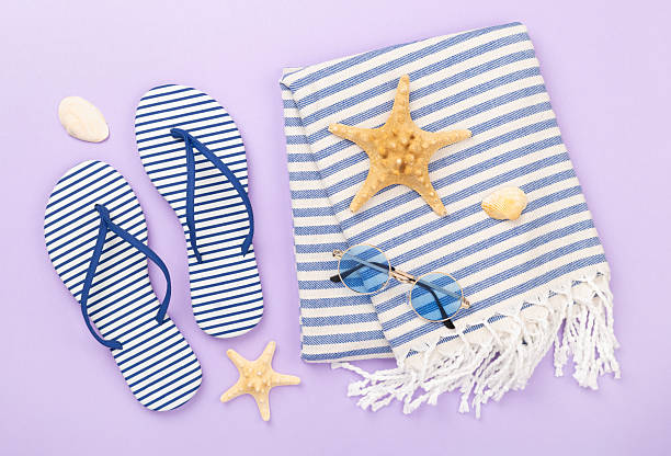 istock Beach towel with summer accessories on color background, top view 2219547791