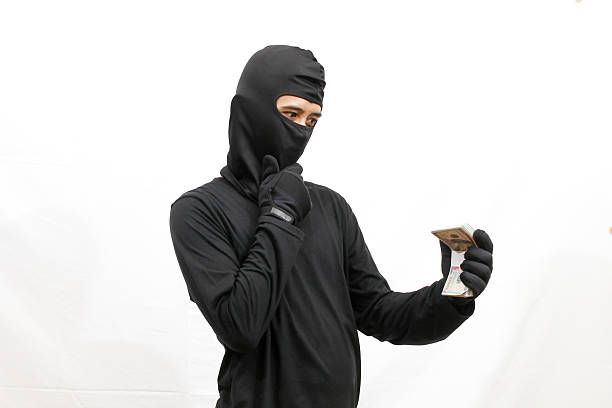 istock thief holding stack of dollar bills feeling confused, isolated on white background 2219551949