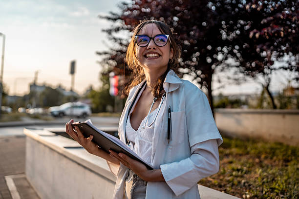 istock Happy Young Professional Smiling Outdoors on a Sunny Day with Notepad 2219552663