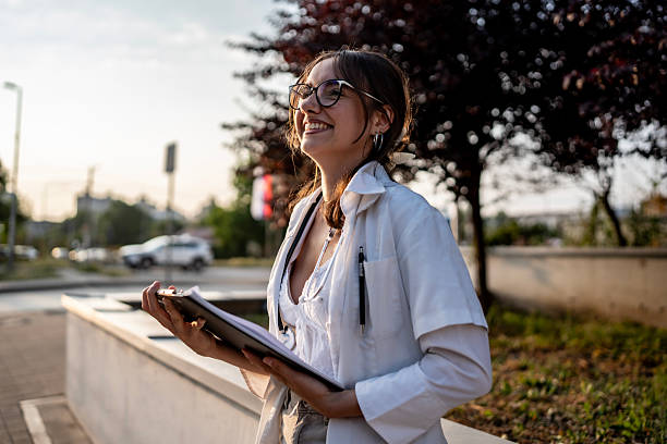 istock Smiling Female Professional Holding Clipboard in Outdoor Setting 2219552675