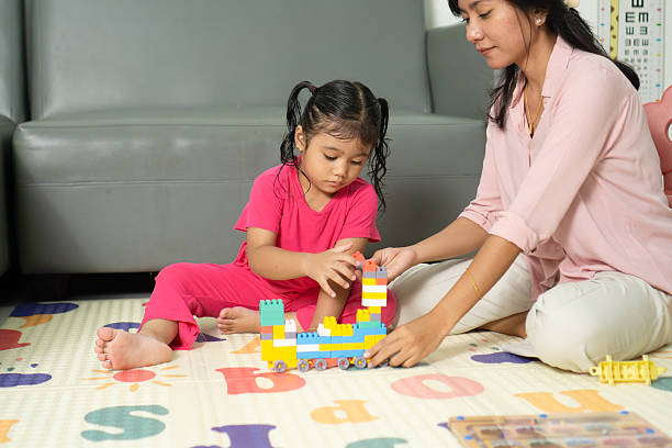 istock Child and Mother Playing with Toy Blocks Together 2219555714