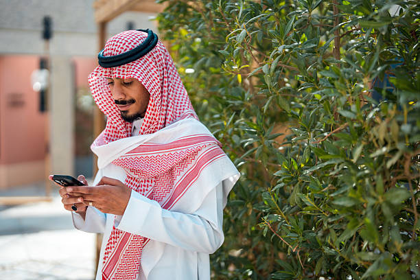 istock Cheerful Young Arabic Male Browsing Smartphone Outdoors 2219558082