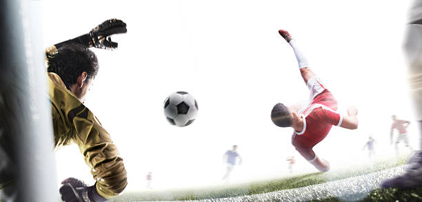 Soccer. A footballer performs a powerful overhead kick while falling. Isolated. Soccer action game. Goalkeeper in action. Rear view