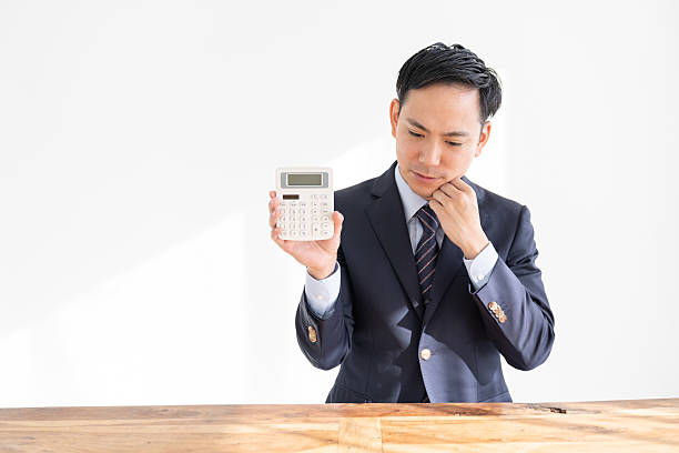 istock young businessman having an electronic calculator,trouble 2219571211