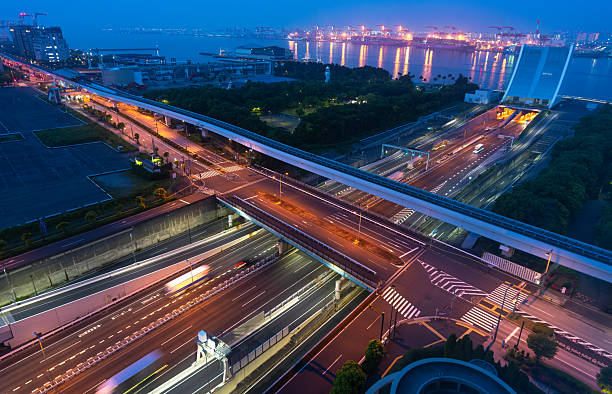 Highway network above waterfront infrastructure with glowing Tokyo Bay port lights at night