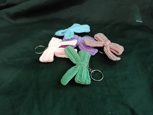 istock Handmade Crochet Keychains with Bow Designs on Dark Fabric Background 2219575762