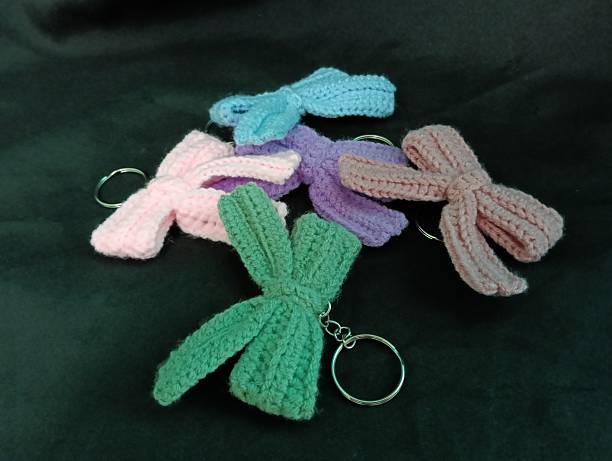 istock Handmade Crochet Keychains with Bow Designs on Dark Fabric Background 2219575768