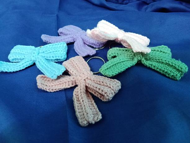 istock Handmade Crochet Keychains with Bow Designs on blue Fabric Background 2219575771