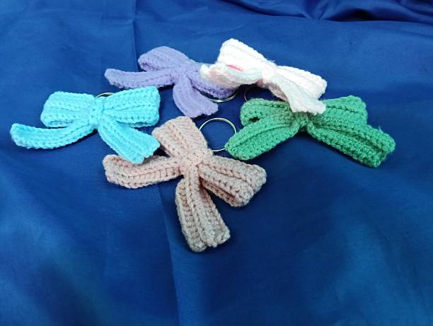 istock Handmade Crochet Keychains with Bow Designs on blue Fabric Background 2219575780