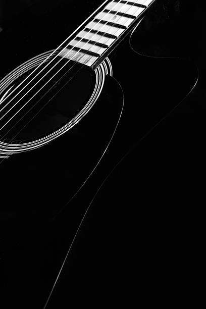istock black acoustic guitar on a black background, silhouette. black and white, close-up, front side view 2219578158