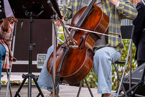 istock Musicians focused on playing cello and violin during a live performance. The image captures the hands and instruments, highlighting the dedication and emotion of the performers. 2219579177