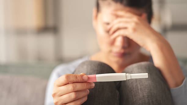 istock Young woman holding pregnancy test with negative result 2219581737
