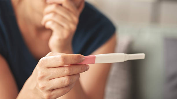 istock Young woman holding pregnancy test with negative result 2219581745