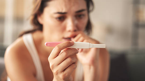 istock Young woman holding pregnancy test with negative result 2219581782