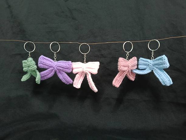 istock Handmade Crochet Keychains with Bow Designs hanging on Dark Fabric Background 2219584703