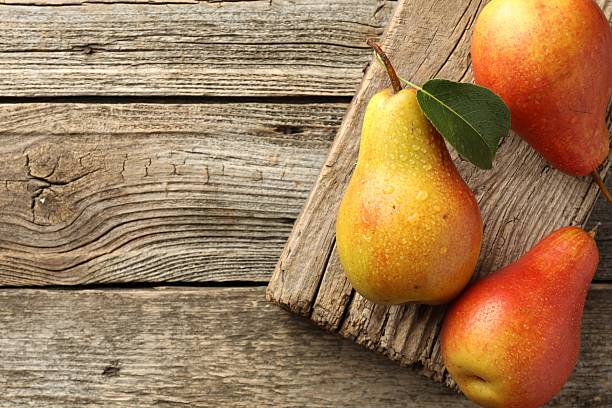 istock Ripe juicy pears on wooden table, top view. Space for text 2219585404